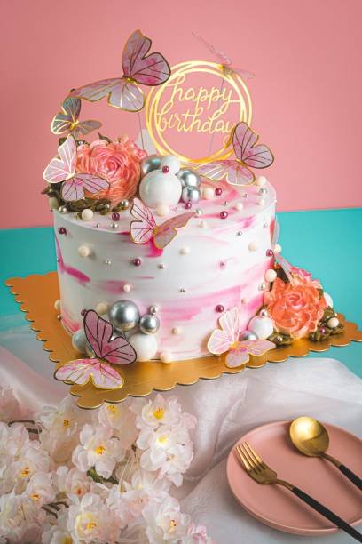 A vertical shot of a beautiful pink birthday cake decorated with butterflies
